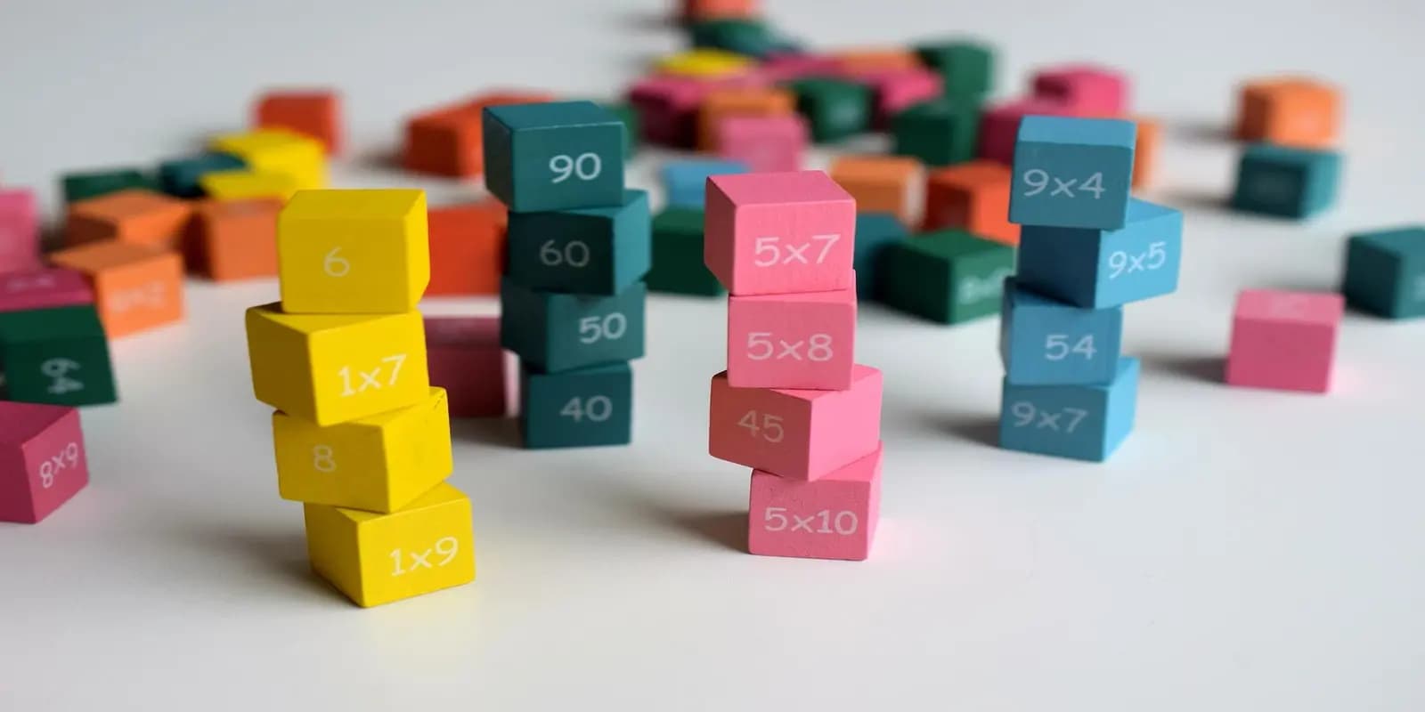 Colorful educational math blocks with multiplication tables and numbers stacked in small towers.