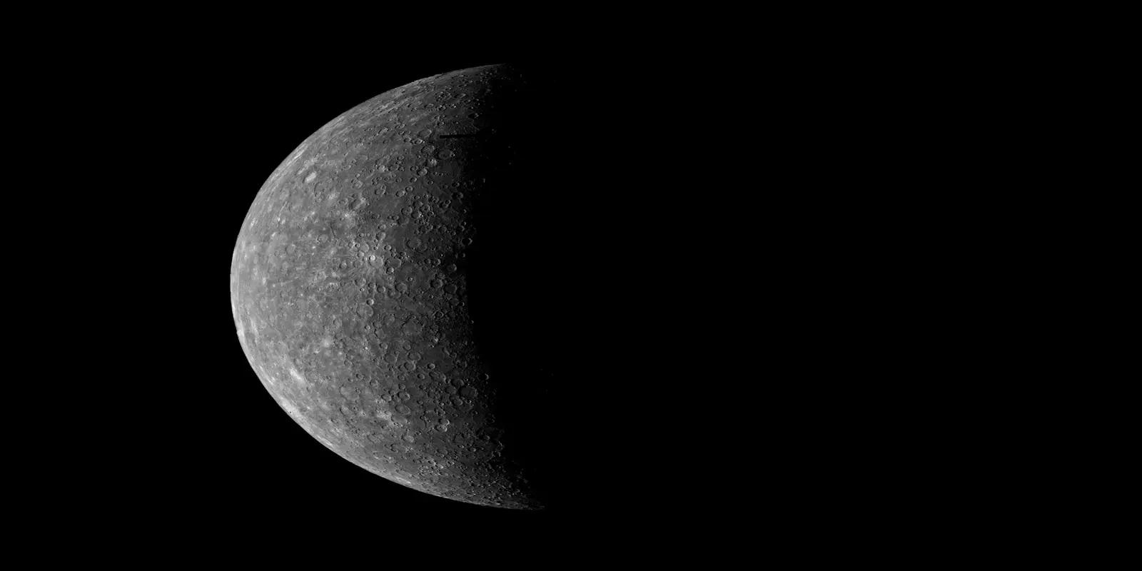 Half crescent view of Mercury showing detailed crater-marked surface against black space background.