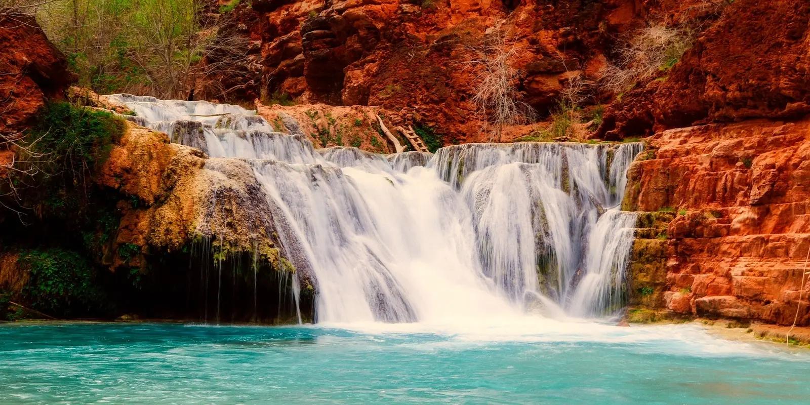 Stunning Havasu Falls cascading over red rock cliffs into turquoise water in the Grand Canyon, Arizona.