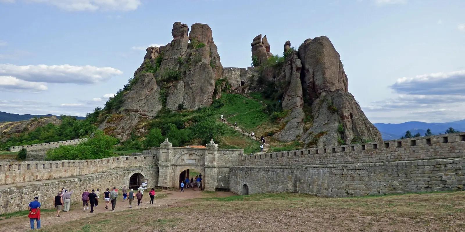 Belogradchik Fortress in Bulgaria, featuring a stone gate and walls leading to unique rock formations.