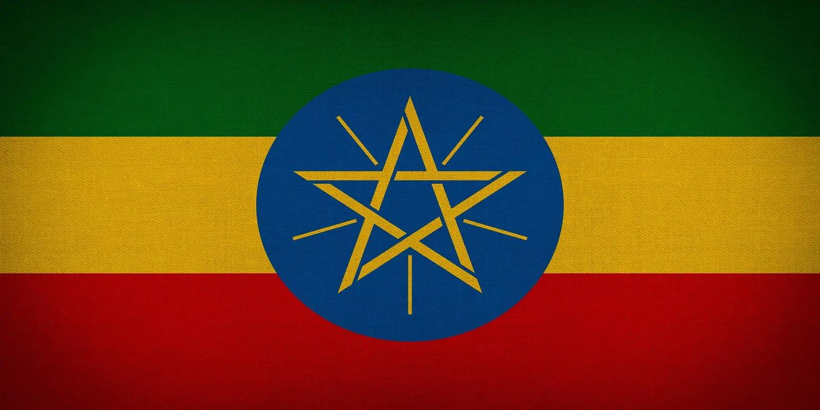 The flag of Ethiopia, featuring horizontal stripes of green, yellow, and red with a central blue disc and a yellow pentagram with rays.