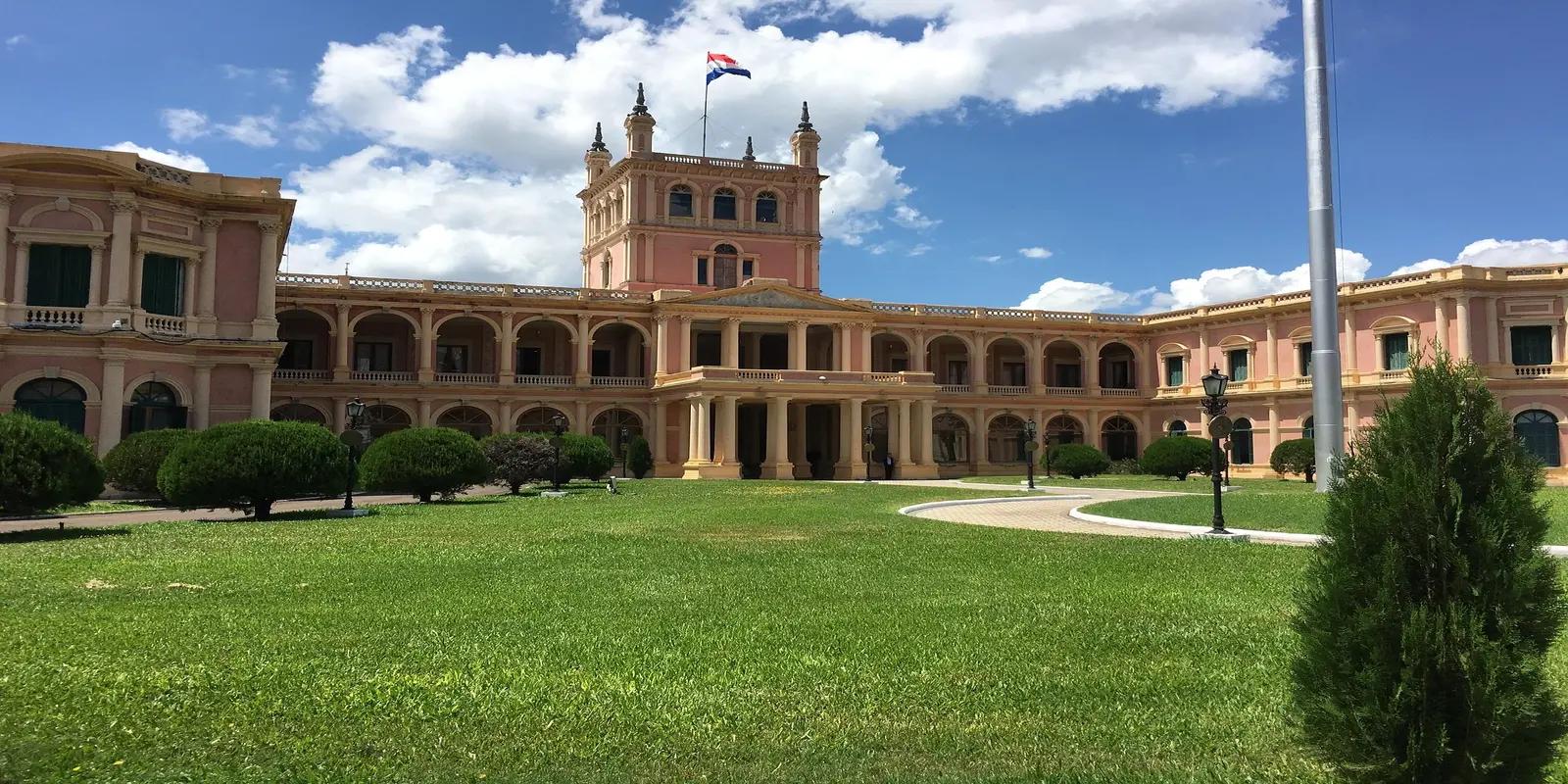 The Palacio de los López, the presidential palace in Asunción, Paraguay, featuring its ornate pink facade, arched colonnades, and central tower with a flag.