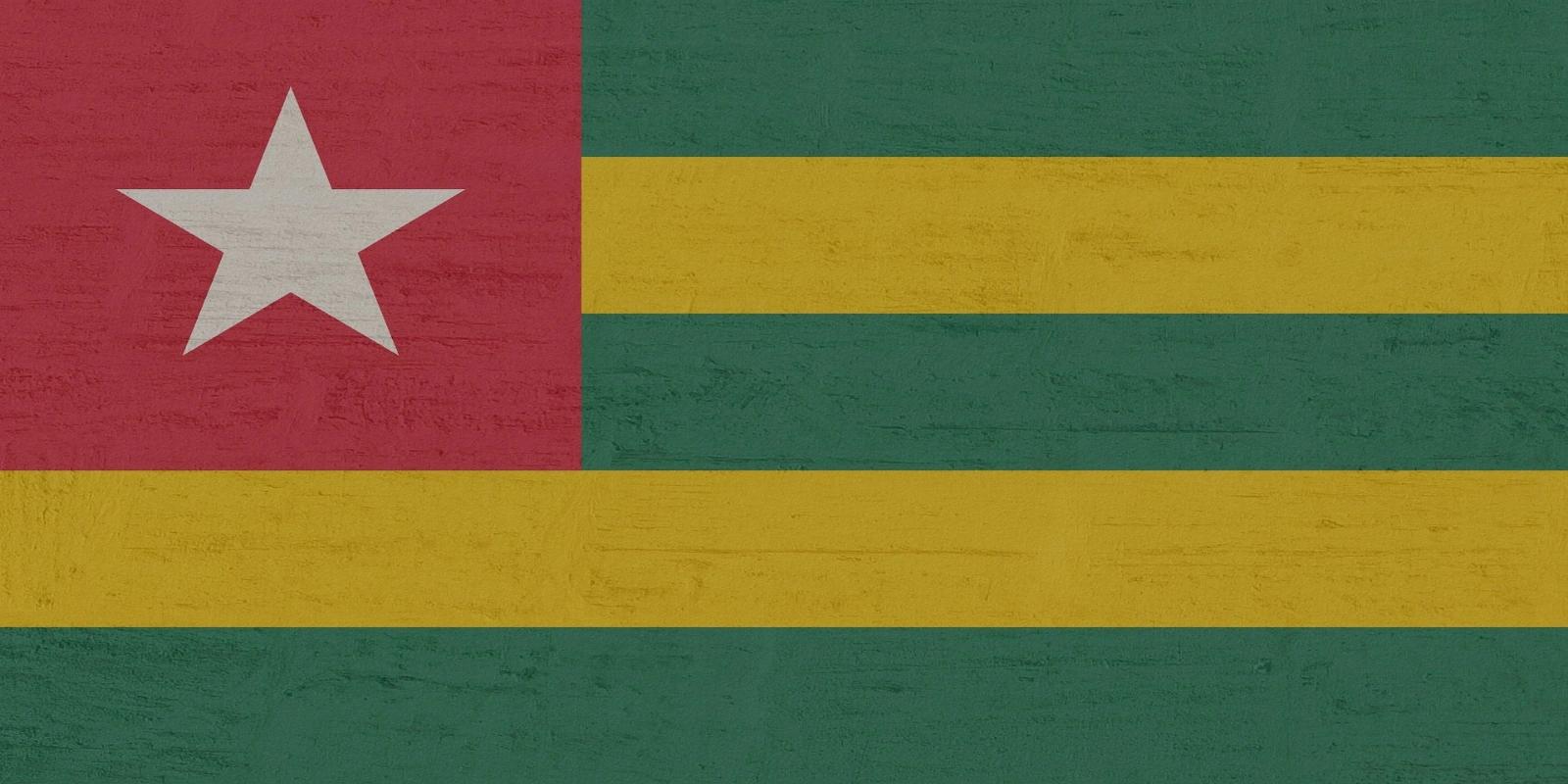 The national flag of Togo, featuring horizontal stripes of green and yellow, with a red square canton containing a white star on the hoist side.