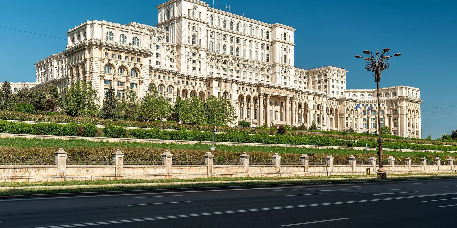 The Palace of the Parliament (Casa Poporului) in Bucharest, Romania, showcasing its massive scale and neoclassical architecture, with a view of its grand facade and surrounding cityscape.